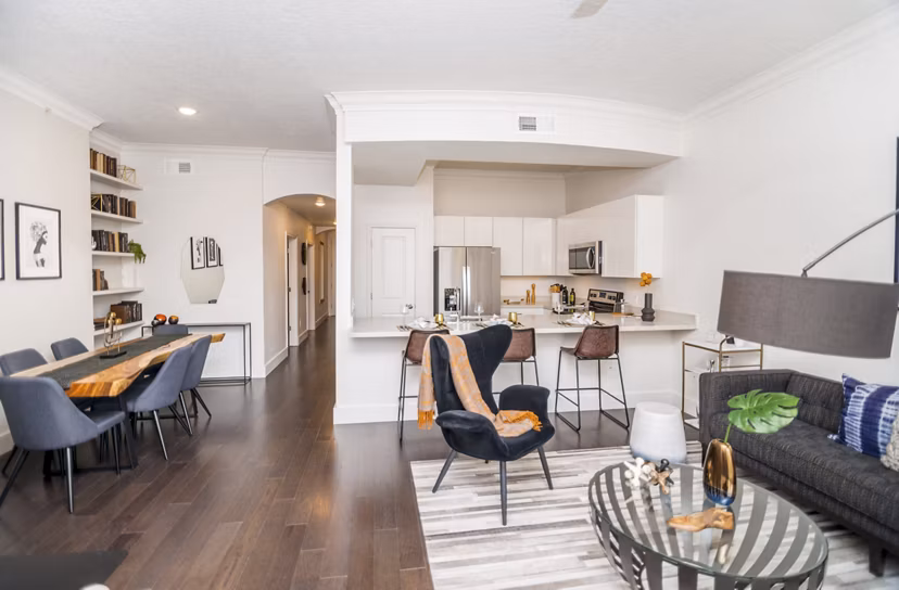 Open-concept living room with modern decor and large windows at Bayou on the Bend Apartments