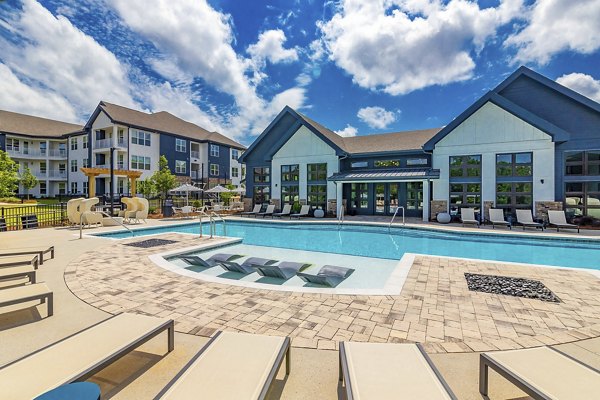 Expansive outdoor pool at Marlowe South Fulton Apartments with modern lounge furniture and surrounding greenery