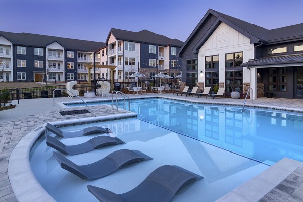 Outdoor pool area with lounge chairs at Marlowe South Fulton Apartments, featuring luxury relaxation amenities