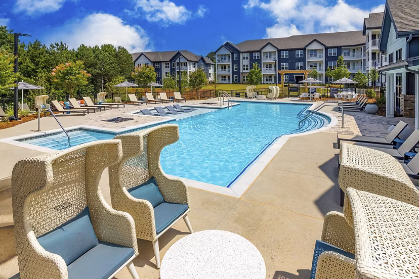 Resort-style pool at Marlowe South Fulton Apartments, featuring spacious lounge area and surrounding lush landscaping