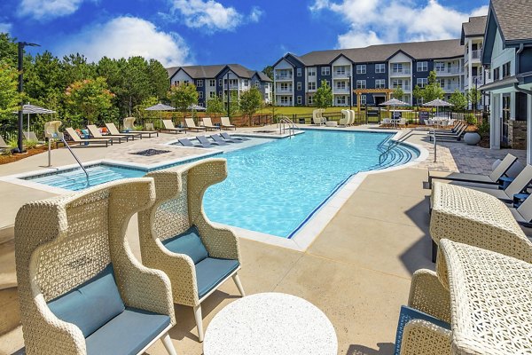 Resort-style pool at Marlowe South Fulton Apartments, featuring spacious lounge area and surrounding lush landscaping