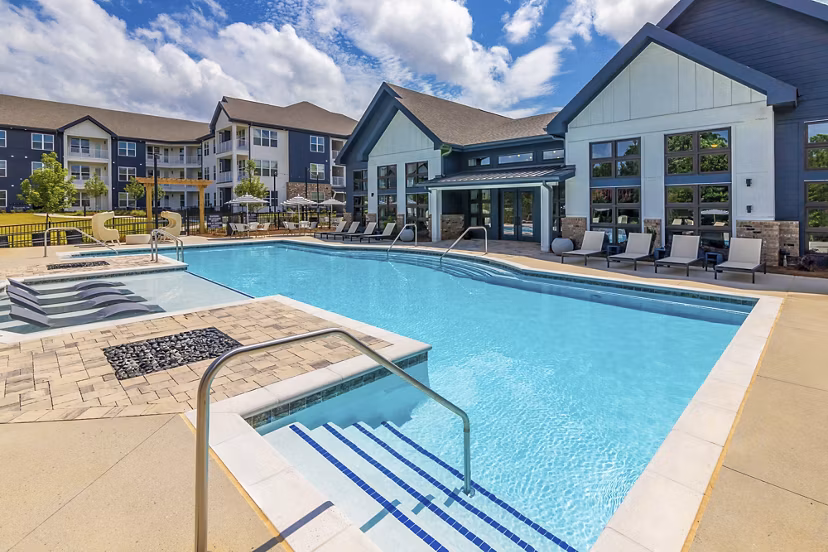 Modern pool at Marlowe South Fulton Apartments featuring lounge chairs and umbrellas