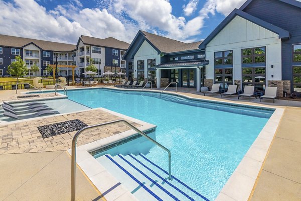 Modern pool at Marlowe South Fulton Apartments featuring lounge chairs and umbrellas