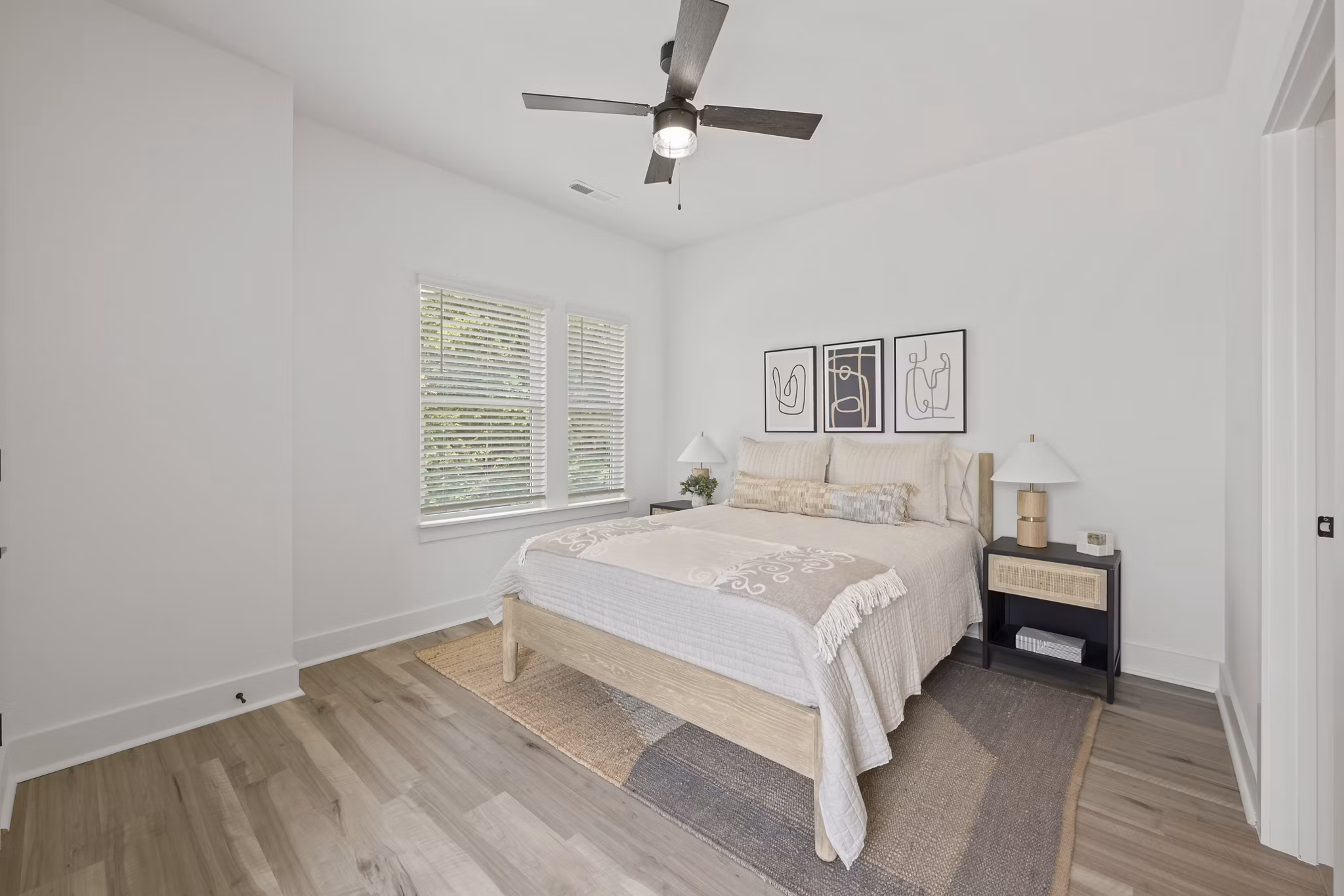 Elegant bedroom with large windows and designer furnishings at Cascadia at Highland Creek Apartments