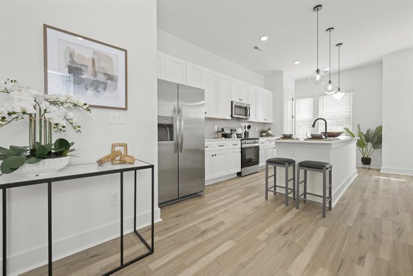 Modern kitchen with granite countertops and stainless steel appliances in Cascadia at Highland Creek Apartments