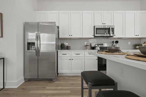 Modern kitchen featuring stainless steel appliances and granite countertops at Cascadia at Highland Creek Apartments