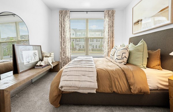Cozy bedroom with modern furnishings at Elan Prosperity Village Apartments, offering luxury living spaces for comfort and style