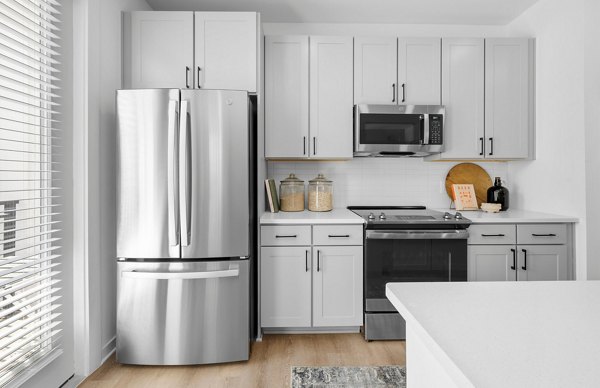 Modern kitchen with stainless steel appliances and granite countertops in Elan Prosperity Village Apartments