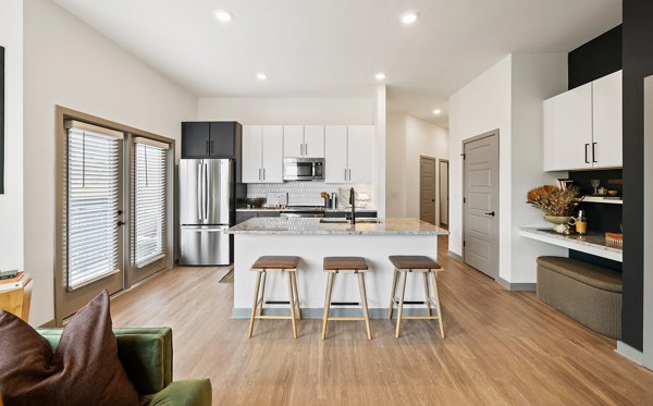 Modern kitchen featuring stainless steel appliances and granite countertops at Asher Apartments