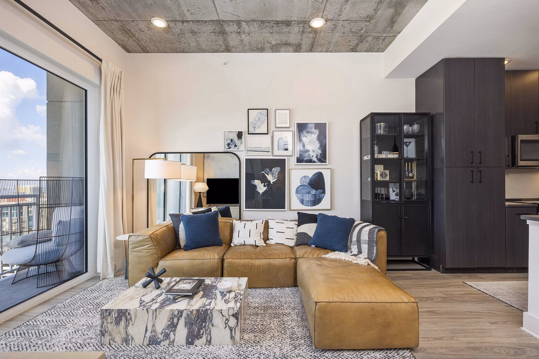 Spacious living room with modern decor and natural lighting at The MAV Apartments