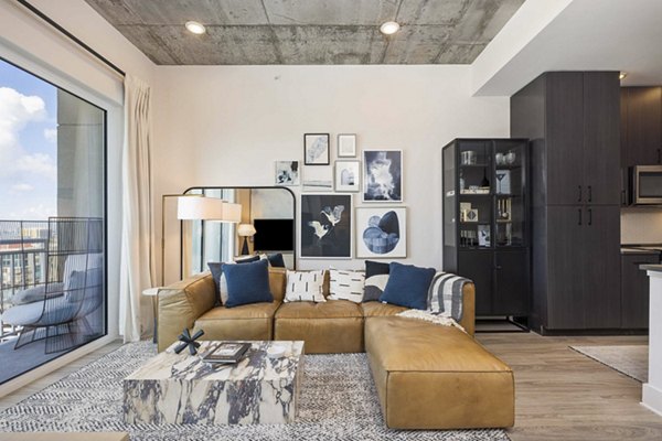 Spacious living room with modern decor and natural lighting at The MAV Apartments