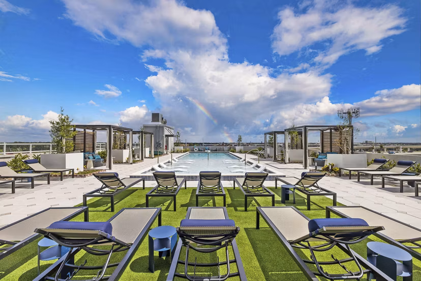 Resort-style pool with lounge chairs at The MAV Apartments, ideal for relaxation in a luxurious setting