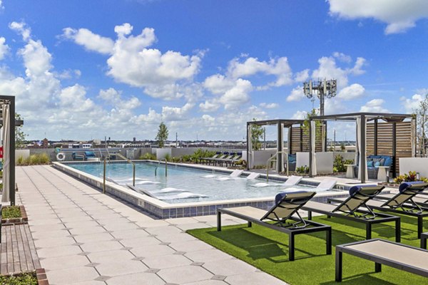 Modern outdoor pool with sun loungers at The MAV Apartments providing luxury relaxation in Greystar community