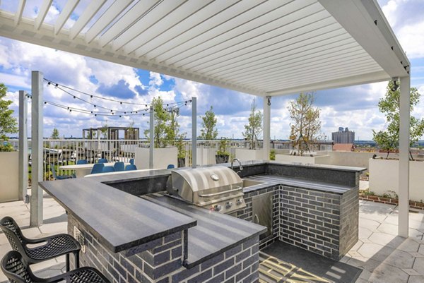 Contemporary outdoor grill area with seating at The MAV Apartments