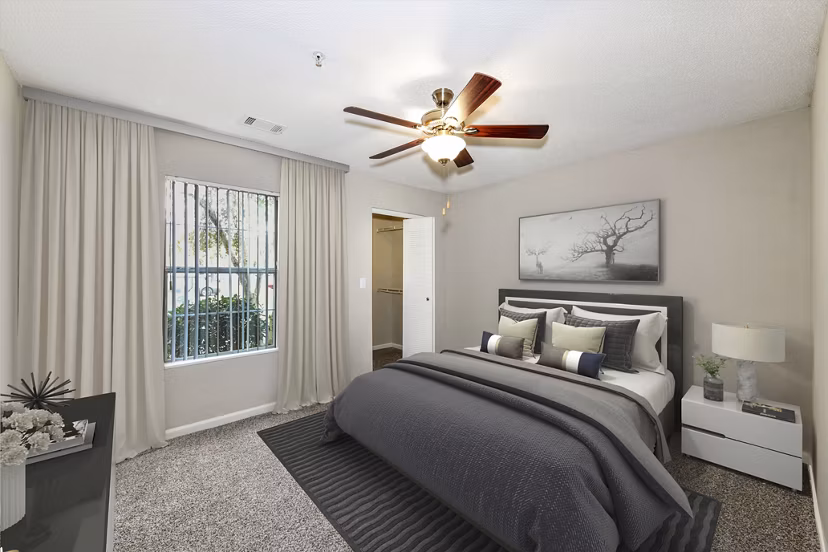 Bedroom with elegant decor, plush bedding, and ample natural light at Signature at Sugarloaf Apartments
