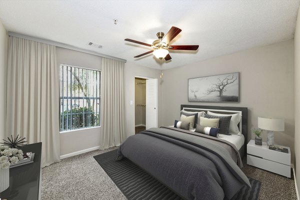 Bedroom with elegant decor, plush bedding, and ample natural light at Signature at Sugarloaf Apartments