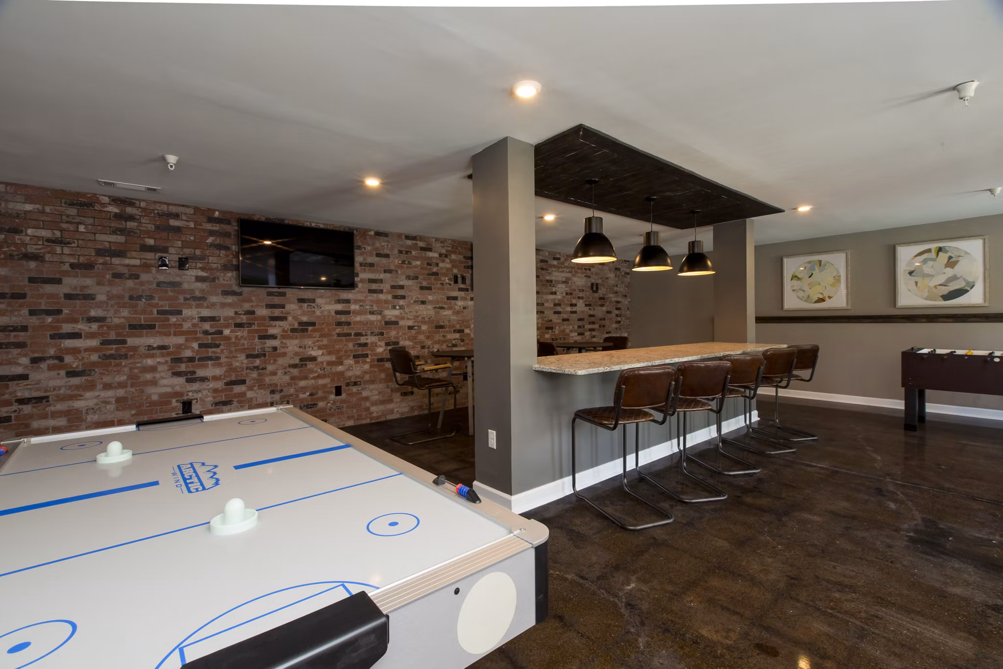 Game room with arcade machines and pool table at Signature at Sugarloaf Apartments