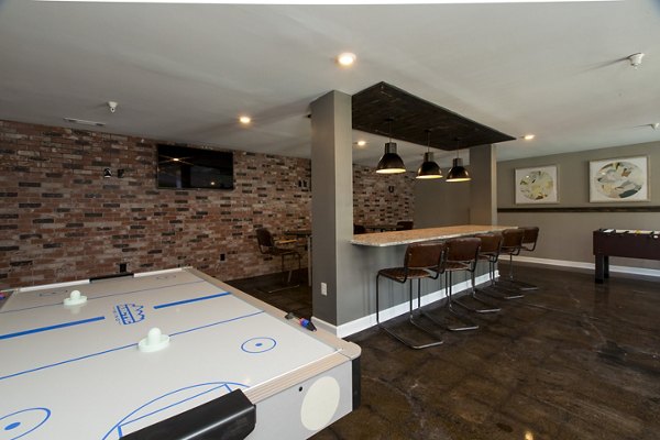 Game room with arcade machines and pool table at Signature at Sugarloaf Apartments