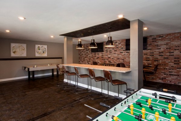 Modern game room with pool table and lounge seating at Signature at Sugarloaf Apartments, offering luxury amenities for residents in Duluth
