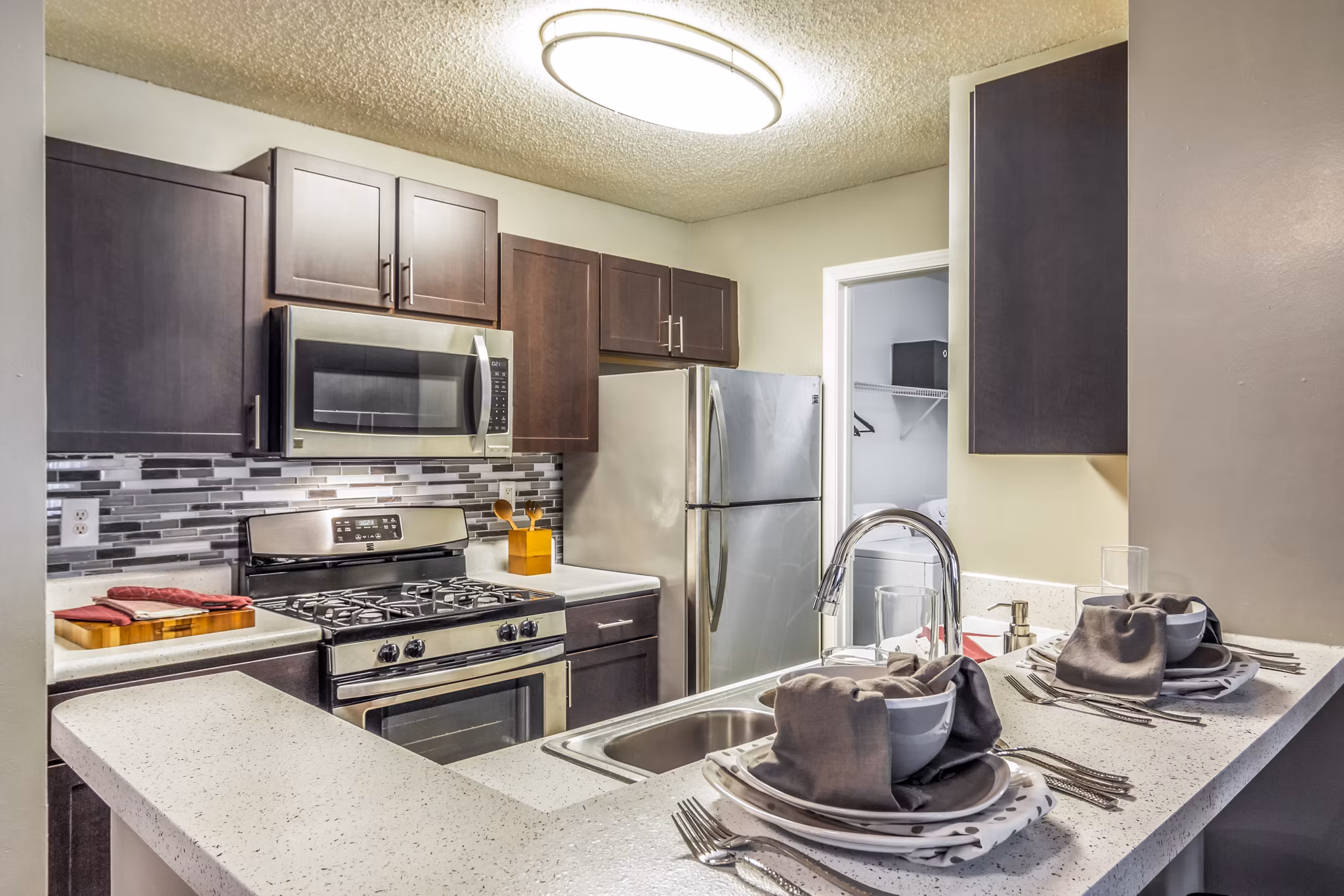 Modern kitchen with stainless steel appliances and elegant design at Signature at Sugarloaf Apartments in luxury setting