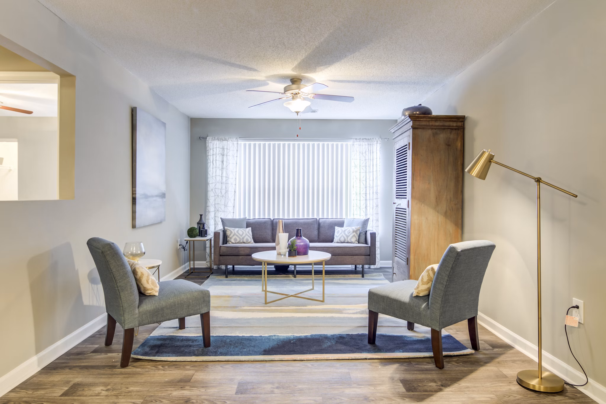 Elegant living room with modern decor and large windows at Signature at Sugarloaf Apartments in Atlanta