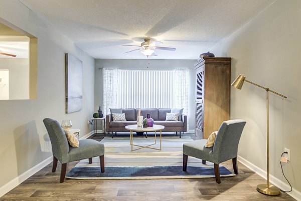 Elegant living room with modern decor and large windows at Signature at Sugarloaf Apartments in Atlanta