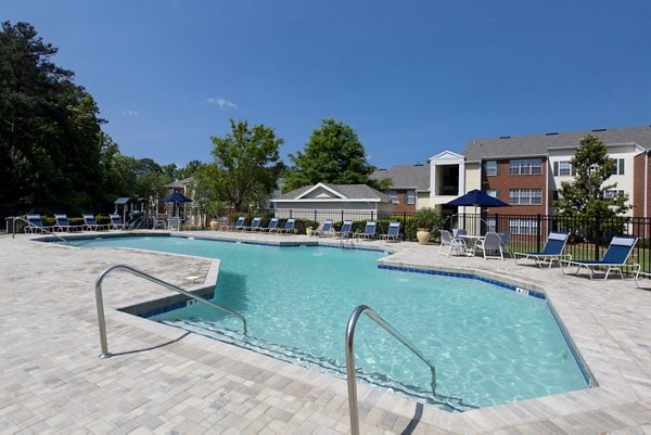 Resort-style pool at Signature at Sugarloaf Apartments with lounge seating and landscaped surroundings