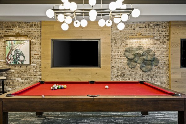 Clubhouse game room featuring pool table and modern seating at The Terra Apartment Homes, ideal for socializing in a luxurious setting