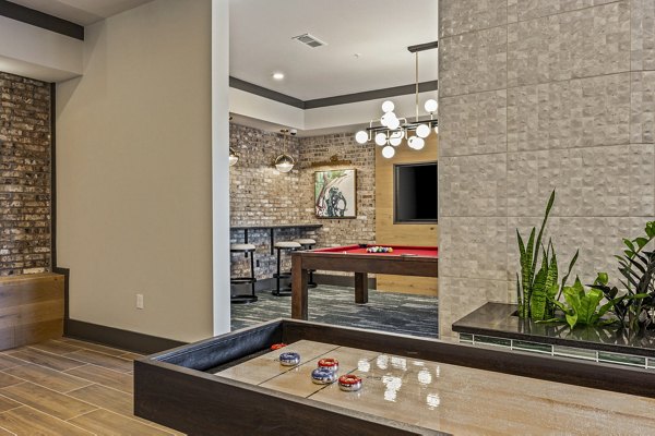 Clubhouse game room with billiards and lounge seating at The Terra Apartment Homes