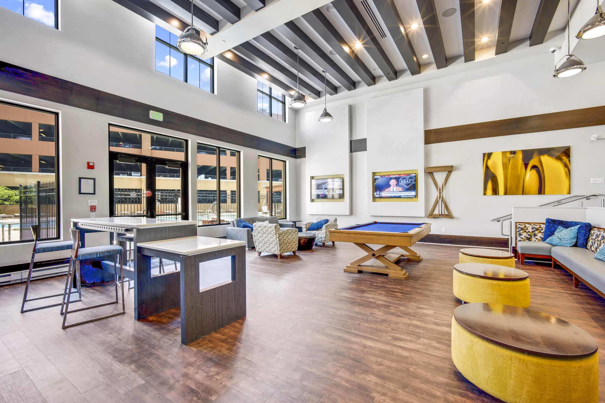 Modern clubhouse game room with billiards and lounge seating at Beckon Apartments