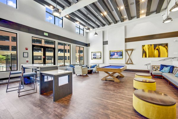 Modern clubhouse game room with billiards and lounge seating at Beckon Apartments