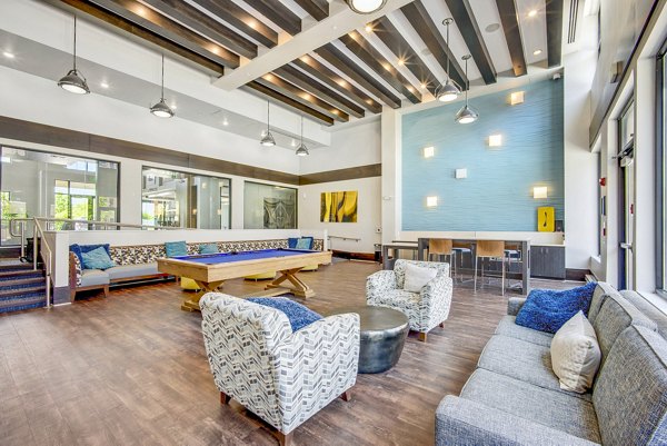 Clubhouse game room with billiards and seating at Beckon Apartments luxury property featuring upscale amenities