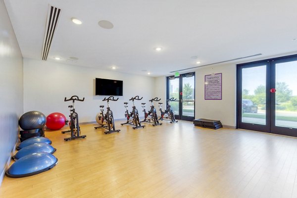 Yoga and spin studio with mirrored walls and exercise bikes at Tapestry Largo Station Apartments