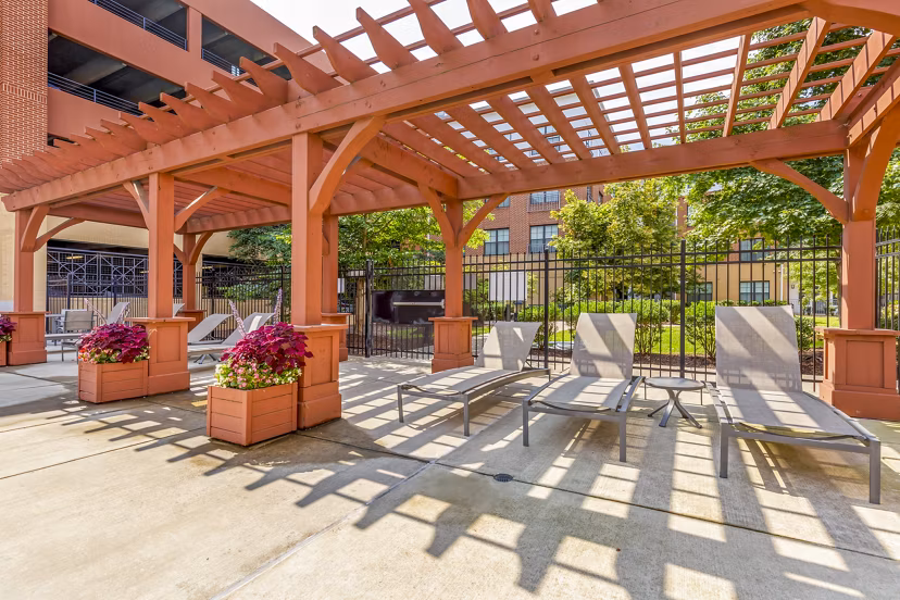 Community pool patio at Tapestry Largo Station Apartments with comfortable lounge seating and modern design