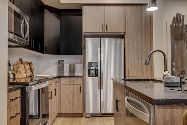 Modern kitchen featuring stainless steel appliances at CINQ Apartments