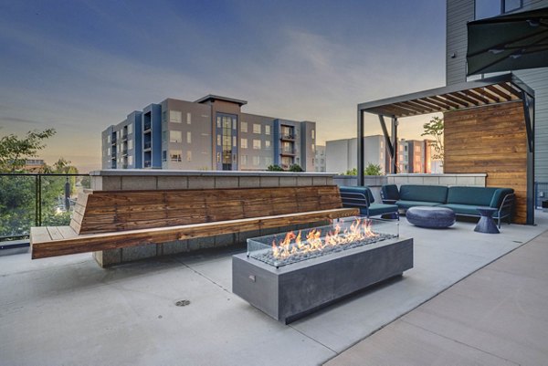 Patio at CINQ Apartments: Modern outdoor seating with lush greenery, perfect for relaxation in Greystar's luxury apartments