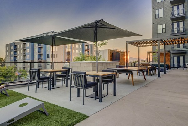 Modern outdoor patio with comfortable seating at CINQ Apartments in dynamic urban setting