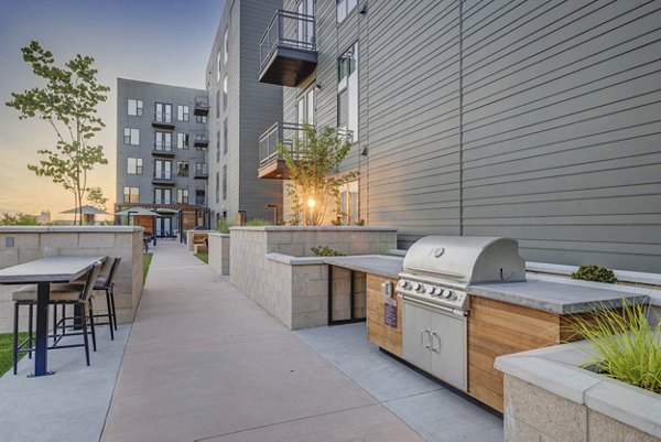 Patio with stylish seating and greenery at CINQ Apartments, luxury living space designed by Greystar