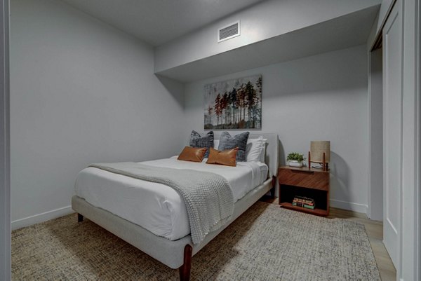 Cozy bedroom with modern decor and natural light at The DeWitt Apartments