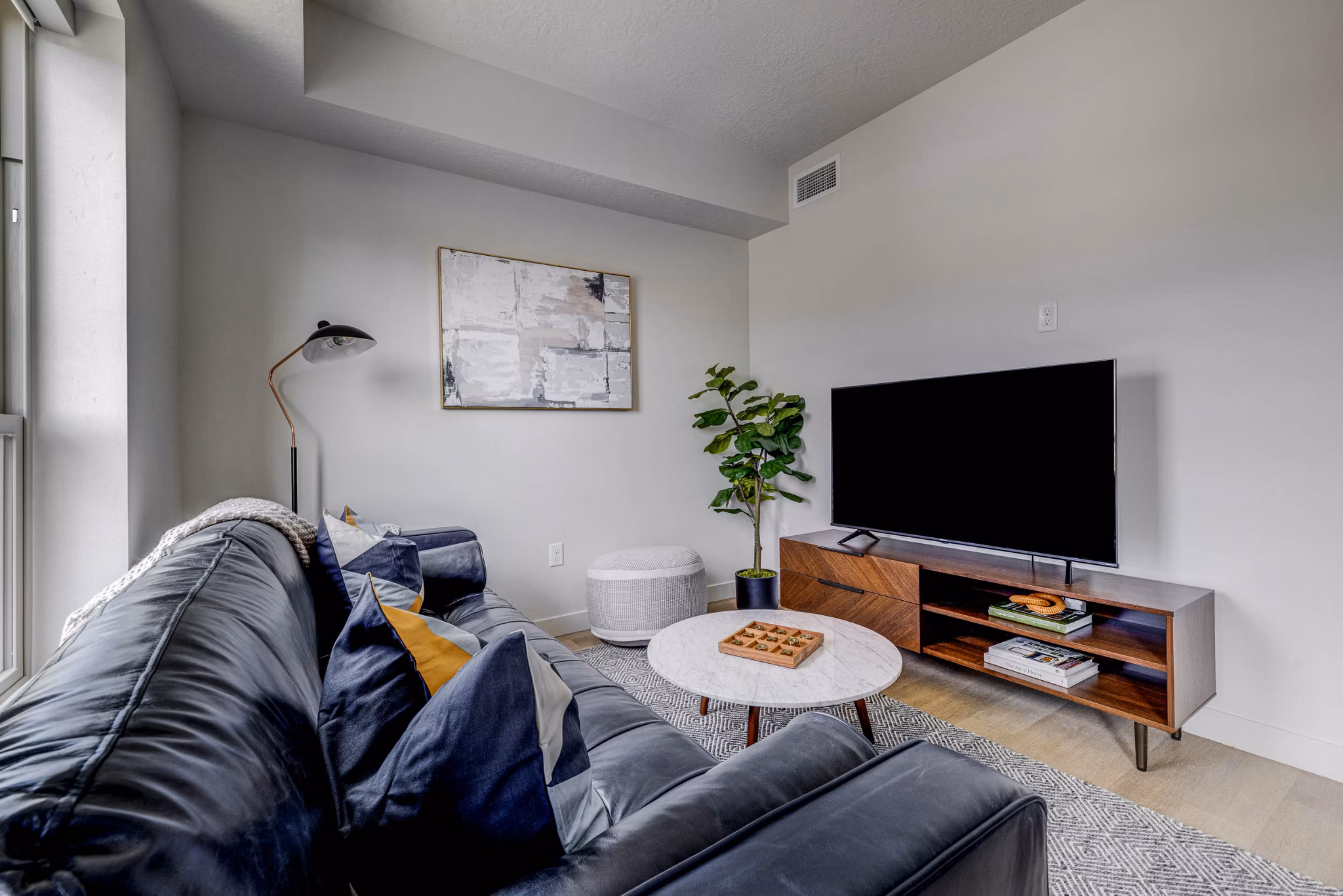 Modern living room with sleek furniture and large windows at The DeWitt Apartments in Chicago