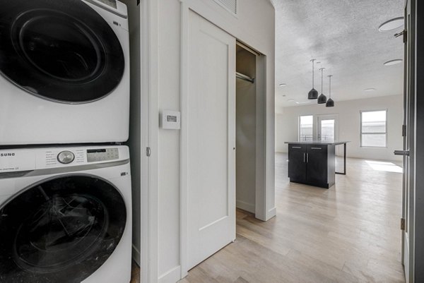 Laundry room with modern washers and dryers at The DeWitt Apartments