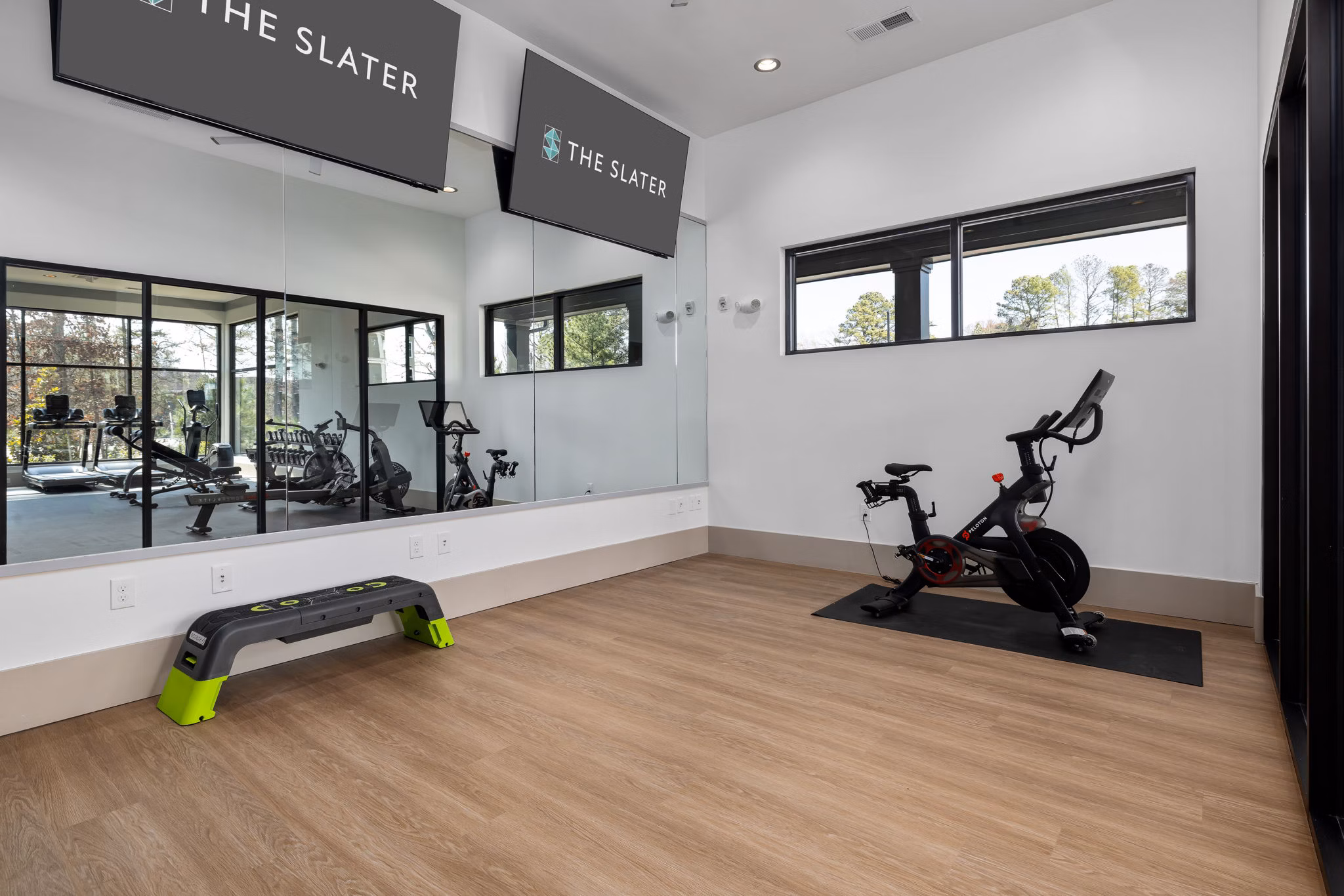 Well-equipped yoga/spin studio at The Slater Apartments featuring modern fitness equipment and spacious interiors