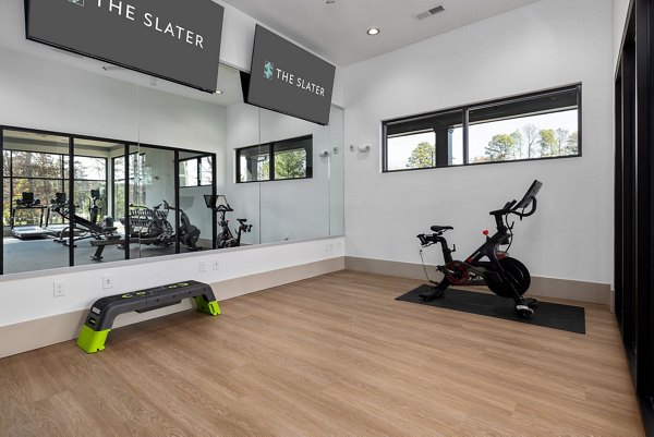 Well-equipped yoga/spin studio at The Slater Apartments featuring modern fitness equipment and spacious interiors