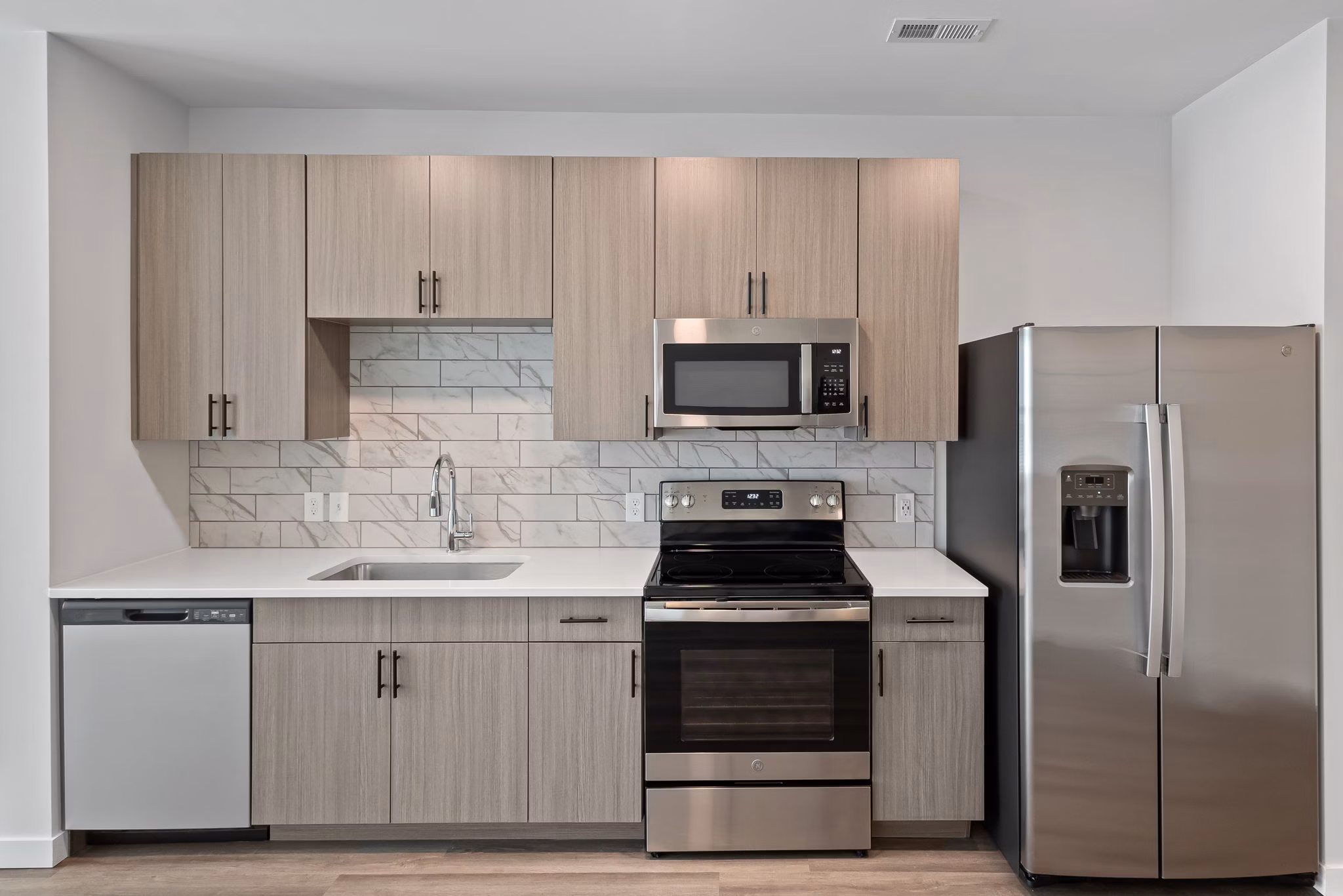 Modern kitchen with stainless steel appliances at The Slater Apartments, offering luxury living spaces in an urban setting
