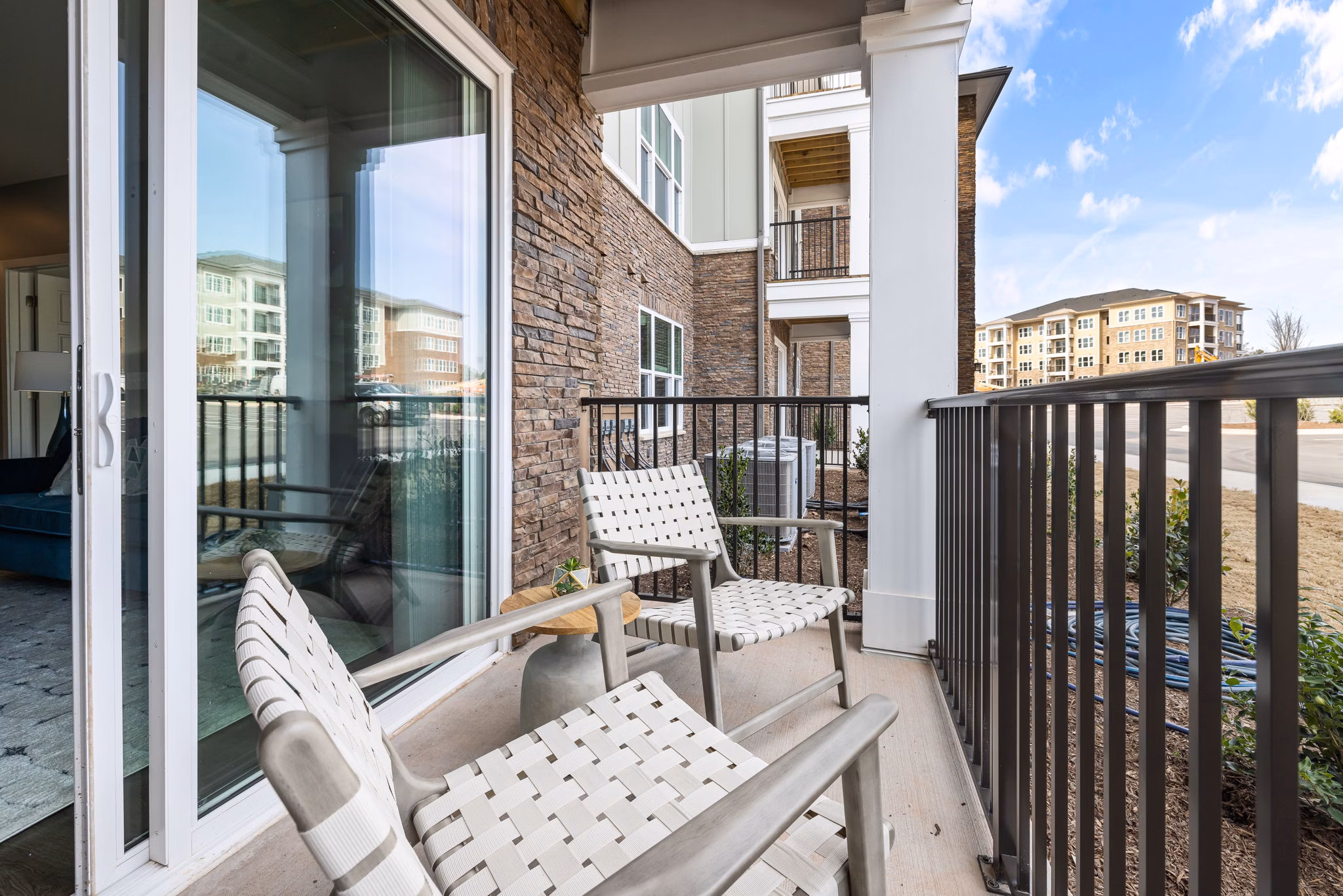 Patio area with modern outdoor furniture at The Slater Apartments, offering a relaxing environment for residents