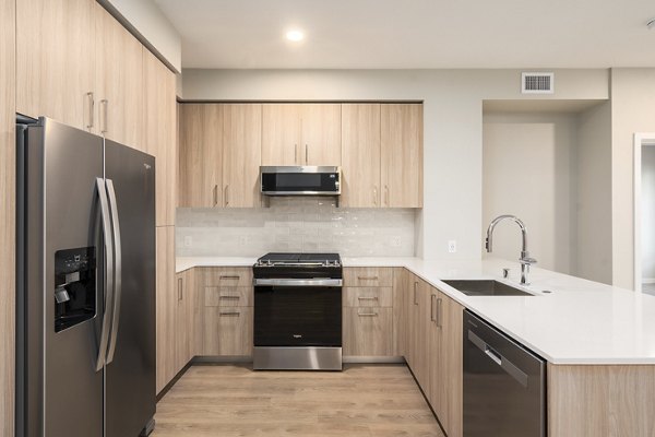 Modern kitchen with stainless steel appliances in Sofia Apartments