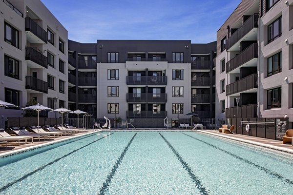 Chic pool area at Sofia Apartments featuring comfortable lounge chairs and lush landscaping