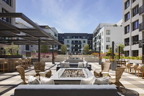 Fire pit area with cozy seating and ambient lighting at Sofia Apartments in Greystar community