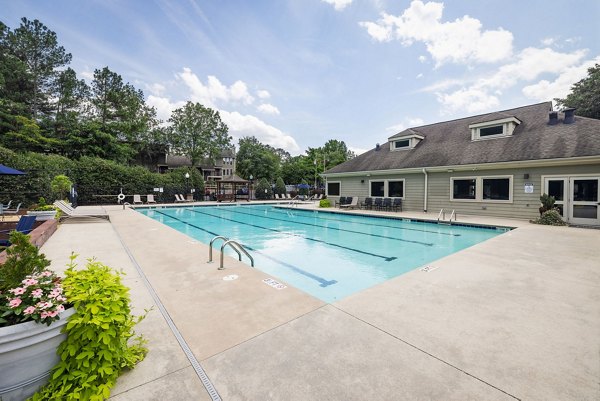 Tranquil outdoor pool surrounded by lush greenery at Shadowood Apartments