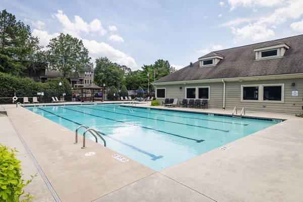 Outdoor pool surrounded by sun loungers at Shadowood Apartments, offering luxury relaxation space in a resort-style setting